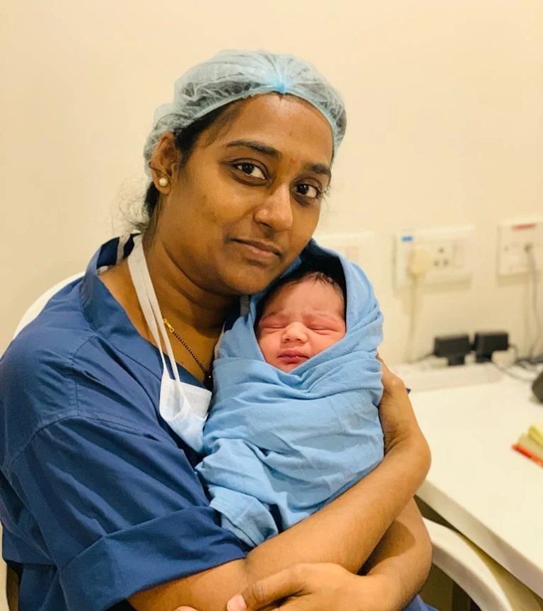 A newborn held by a member of the clinic's team after delivery